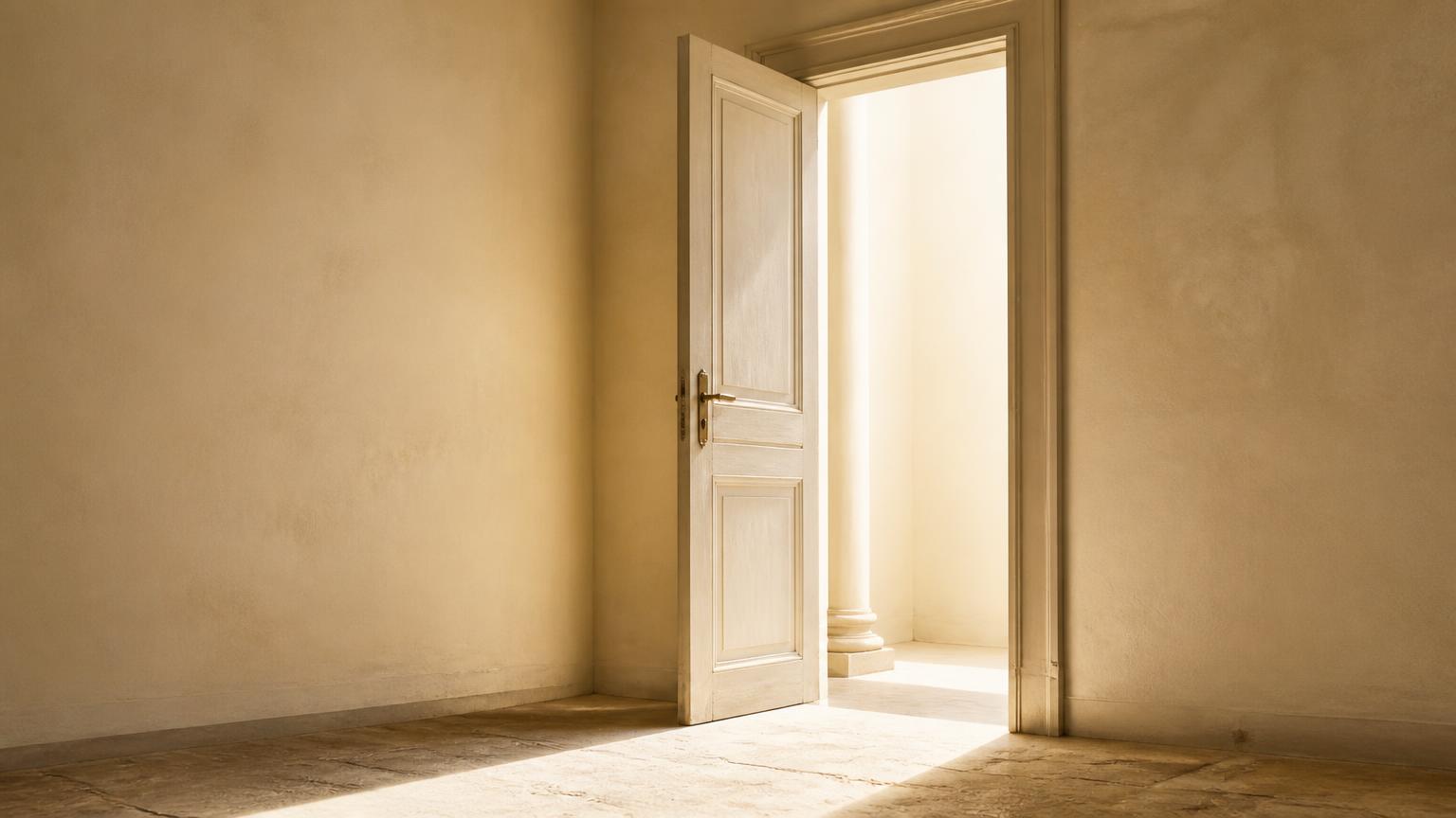 A pale doorway standing ajar, light spilling across a stone floor